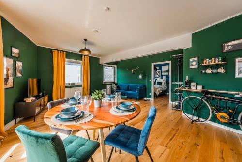 埃森Klassen Stay - Exklusives Apartment - Zentral und 4km zur Messe -Kingsizebett的一间拥有绿色墙壁和桌椅的用餐室