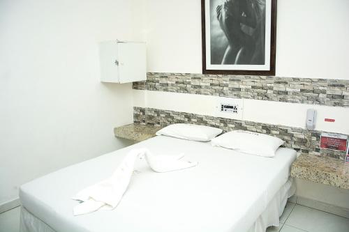 萨尔瓦多艾利珍斯酒店的客房内的一张带两个枕头的白色床