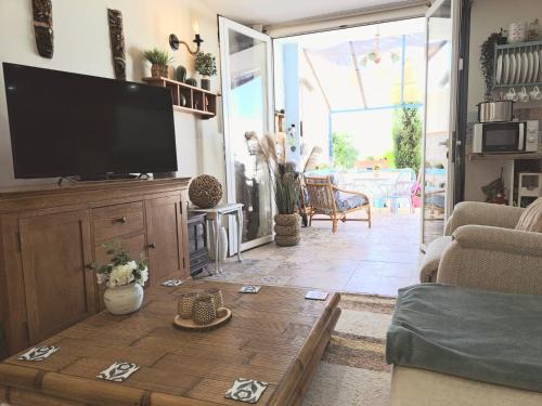 Casa de los Suenos Granada的客厅配有电视和木制咖啡桌。
