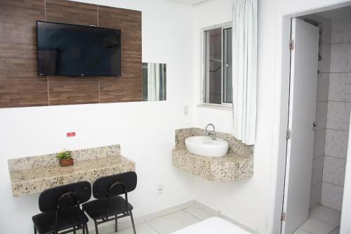 萨尔瓦多艾利珍斯酒店的一间带水槽的浴室和墙上的电视