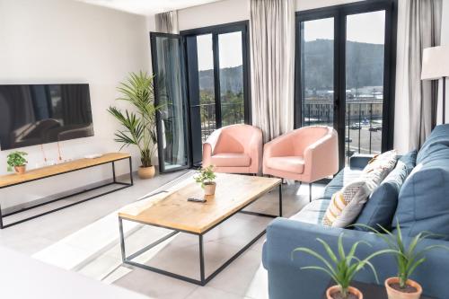 卡塔赫纳Apartamentos Turísticos Puerta Real的客厅配有蓝色的沙发和粉红色的椅子
