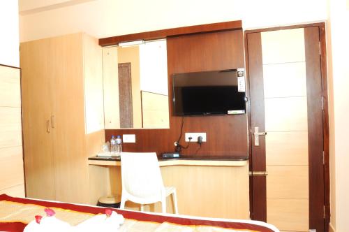 钦奈Sai Budget Hotel Chennai Airport的客房设有带水槽的厨房和电视。