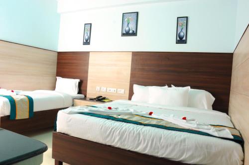 钦奈Sai Budget Hotel Chennai Airport的酒店客房设有两张带玫瑰花的床。