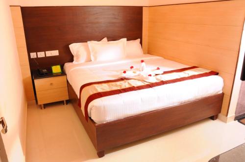 钦奈Sai Budget Hotel Chennai Airport的一间卧室,床上放着两只动物