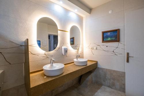 库萨达斯周日海滩酒店的浴室设有2个水槽和镜子