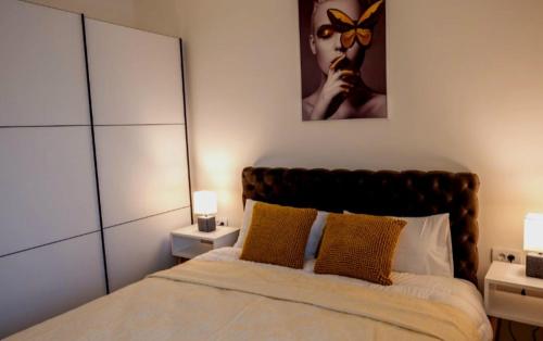 克拉列沃Apartment Leona的一间卧室配有一张带两盏灯和镜子的床