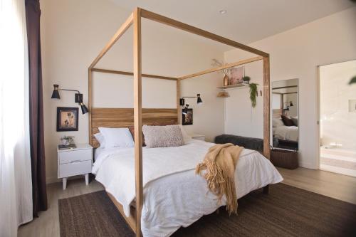 二十九棕榈村Modern Desert Dream - NEW BUILD的一间卧室配有天蓬床和镜子