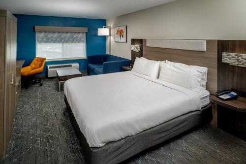 查尔斯顿Holiday Inn Express - Charleston/Kanawha City, an IHG Hotel的酒店客房带一张大床和一把椅子