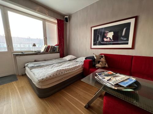 斯德哥尔摩Etage flat Stockholm Stora Essingen的一间卧室配有一张床和一张红色的沙发