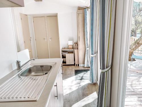 罗克布伦河畔阿尔让3 bedroom Chalets Camping Leï Suves - JoyCasa的白色的厨房设有水槽和窗户