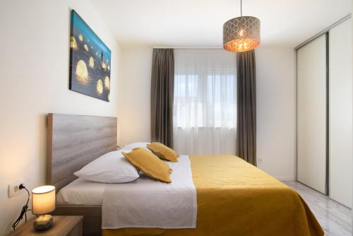 希杰弗朗吉卡Villa Barbara & Zoran with heated swimming pool的一间卧室配有一张带黄色床单的床和一扇窗户。