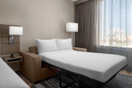 迈阿密AC Hotel by Marriott Miami Dadeland的一间设有窗户的酒店客房内的一张白色床
