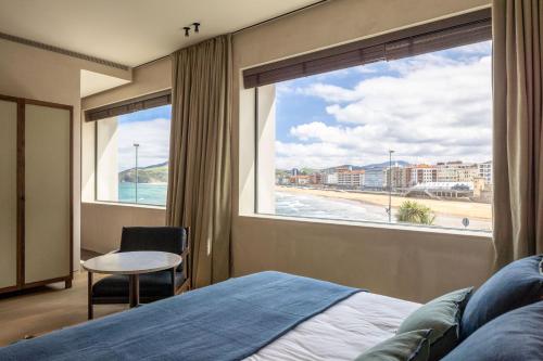 扎鲁亚斯Hotel Ur Bare的一间卧室设有大窗户,享有海滩美景