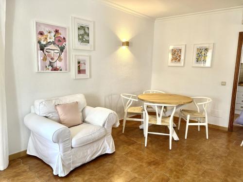 阿尔库迪亚Elena Playa Sol的客厅配有白色椅子和桌子