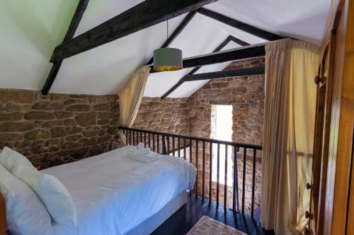 PaulBeautiful Cornish barn in the stunning Lamorna valley with large garden的一间卧室设有一张床和石墙
