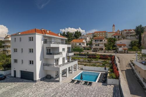 希杰弗朗吉卡Villa Barbara & Zoran with heated swimming pool的一座白色的建筑,在建筑物旁边设有游泳池