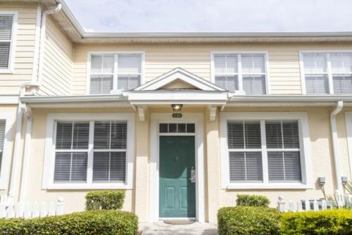 基西米Charming 3-Bedroom Villa in Gated Community - Your Perfect Getaway!的一座带绿门和窗户的房子