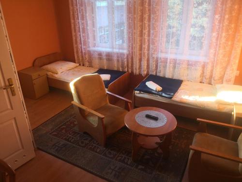 切霍齐内克Ośrodek Wypoczynkowy Janówka的客房设有两张床、椅子和桌子。