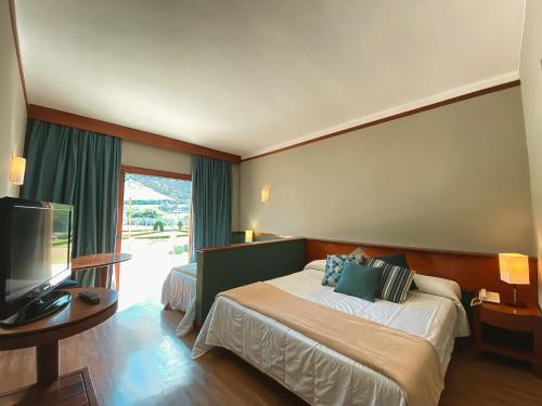 伊泰帕瓦Villa Itaipava Resort & Conventions的配有一张床和一台平面电视的酒店客房