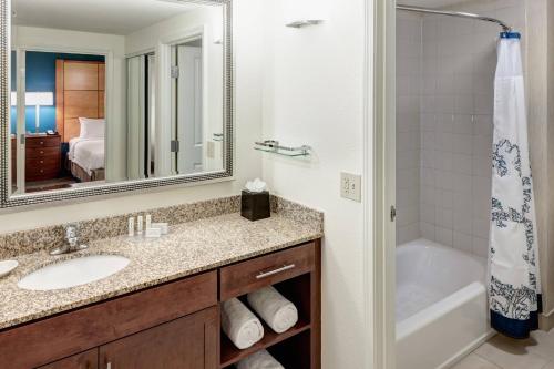 凤凰城凤凰城北欢乐谷原住酒店的一间带水槽、浴缸和镜子的浴室