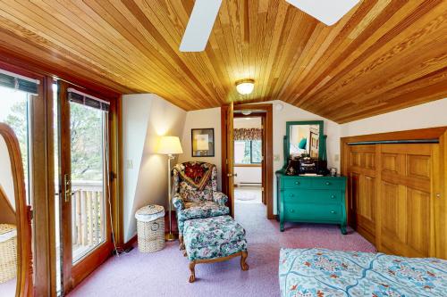 卡农海滩Cannon Beach Cottage的一间卧室设有木制天花板、椅子和梳妆台