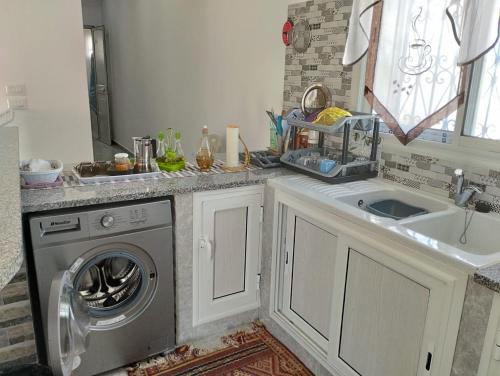 古莱比耶magnifique maison, bien équipé的厨房配有洗衣机和水槽