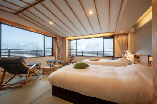 藏王温泉石清水季之里料理旅馆的一间卧室设有两张床和大窗户