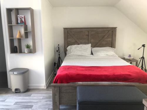 巴尔的摩roceruzdevelopments llc的一间卧室配有一张大木床和红色毯子