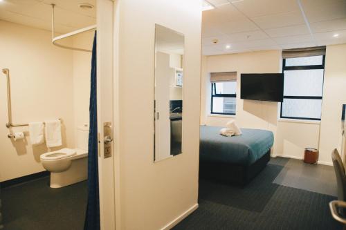 惠灵顿Park Hotel, Lambton Quay的酒店客房设有一张床和一个卫生间。