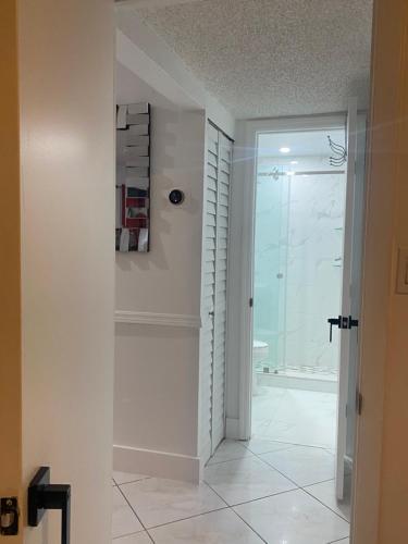 迈阿密Beautiful House 7 min from Miami Airport w FREE parking的带淋浴的浴室和玻璃门