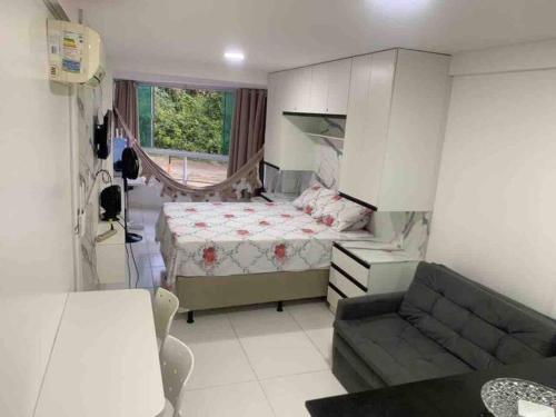 康德Flat Beira Mar Carapibus的一间带床和沙发的小卧室