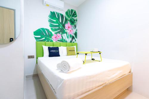 JabiUrbanview Hotel R House Batam的一间卧室配有一张白色床和绿色床头板