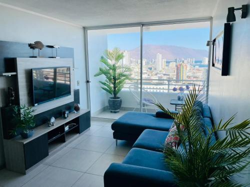 伊基克Departamento con espectacular Ubicación, Vista al Mar y Panorámica a todo Iquique的客厅设有蓝色的沙发和大窗户