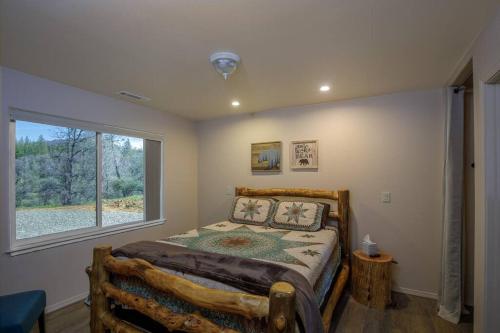 马里波萨Cozy Cub Cabin, brand new home near Yosemite的一间卧室设有一张床和一个大窗户