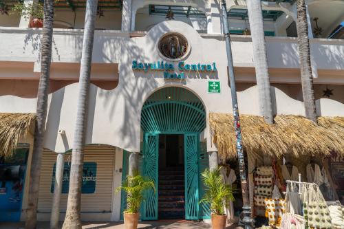 萨尤利塔Sayulita Central Hotel的一座拥有蓝门和棕榈树的建筑