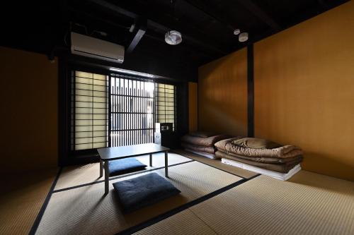 京都Teahouse Rouji的客房设有桌子、床和窗户。