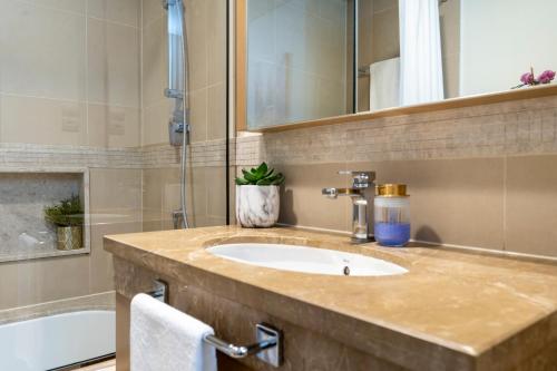 迪拜Prestige Living 1BR with Full Burj Khalifa View by Auberge的浴室配有盥洗盆和浴缸。