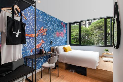 吉隆坡lyf Chinatown Kuala Lumpur的一间卧室设有一张床和蓝色的墙壁