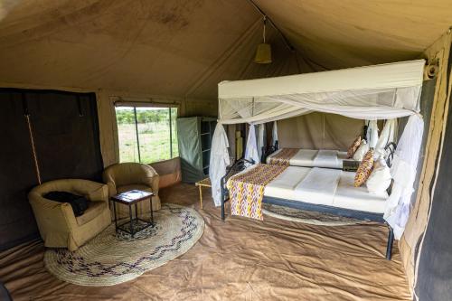 塞伦盖蒂塞伦盖蒂野外露营地的帐篷内的卧室,配有一张床和椅子