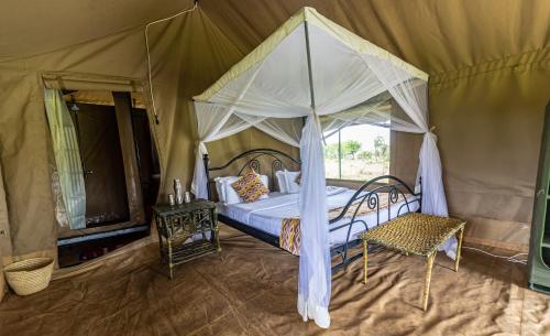 塞伦盖蒂塞伦盖蒂野外露营地的一间帐篷内带天蓬床的卧室