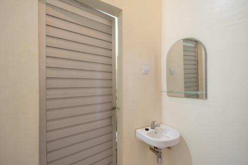 SolokRedDoorz Syariah near RS Tentara Solok的白色的浴室设有水槽和镜子