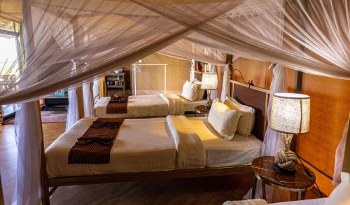 巴纳吉塞伦盖蒂狩猎山林小屋的一间卧室设有两张床和天篷