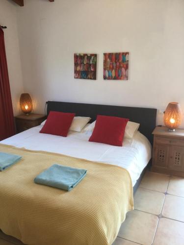 哈维亚Casita in Javea with garden and pool - dog friendly!的一间卧室配有两张带红色枕头的床。