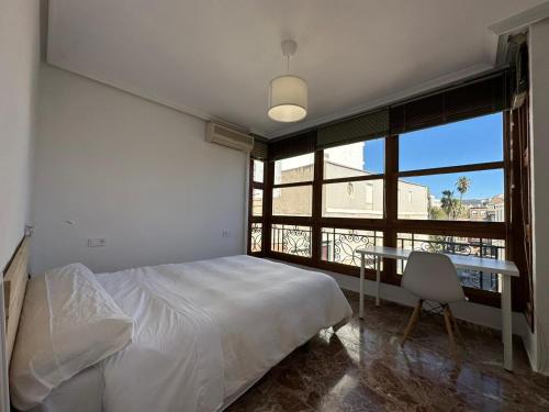 卡塔赫纳Experiencia Centro Cartagena的一间卧室配有一张床、一张桌子和一个窗户。