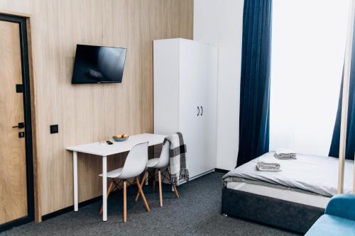 乌日霍罗德RESA apart - нові smart-квартири біля річки的配有一张床和一张桌子及椅子的房间