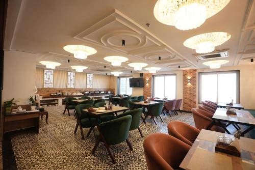大诺伊达Lime Tree Hotel and Banquet Greater Noida的餐厅设有桌椅和吊灯。