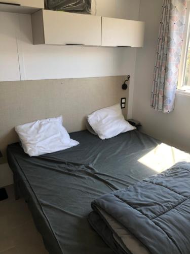 塞特港Camping le Castellas的一张床上有两个枕头的房间