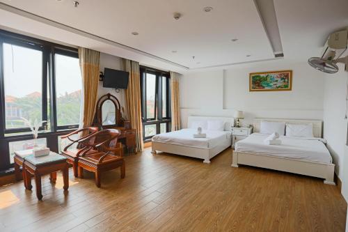 岘港SeaColor Beachstay Danang Hotel by Haviland的大房间设有两张床和一张桌子