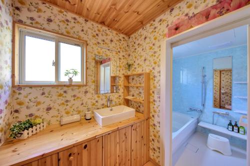 富士河口湖Retreat Camp Mahoroba的一间带水槽和浴缸的浴室