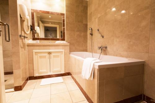 格罗宁根Boutique Hotel De Doelen的带浴缸、淋浴和盥洗盆的浴室